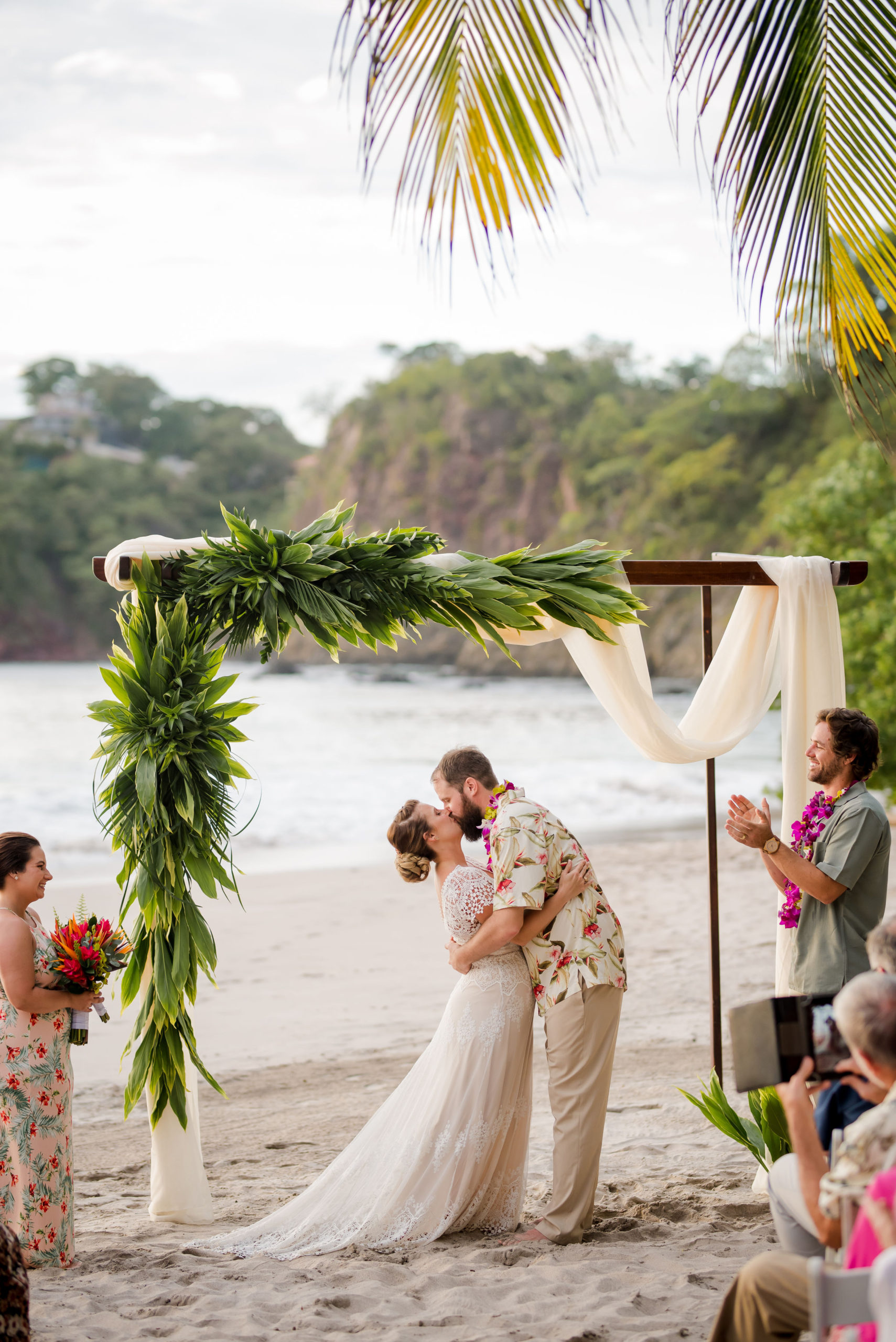 Newlyweds kiss on the beach of Costa Rica property Margaritavilla Beach Resort in dream destination wedding